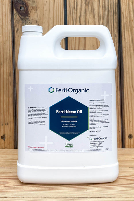 A white plastic jug of Ferti-Organic Ferti-Neem Oil standing on a wooden surface against a wooden plank background.