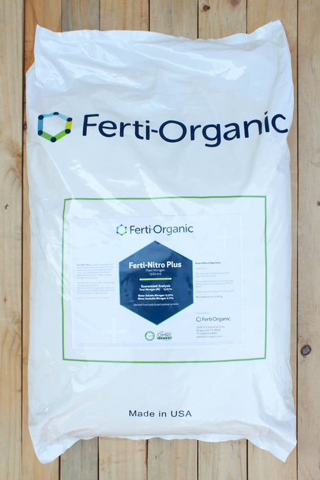 A large white plastic bag of Ferti-Organic Ferti-Nitro Plus fertilizer, laid flat on a light-colored wooden plank surface. The bag features the Ferti-Organic brand name and logo in dark blue and green, with a central label showing the product name and a blue hexagonal graphic.