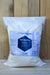 A large white plastic bag of Ferti Organic Ferti-Nitro Plus fertilizer, standing upright against a light-colored wooden plank background.
