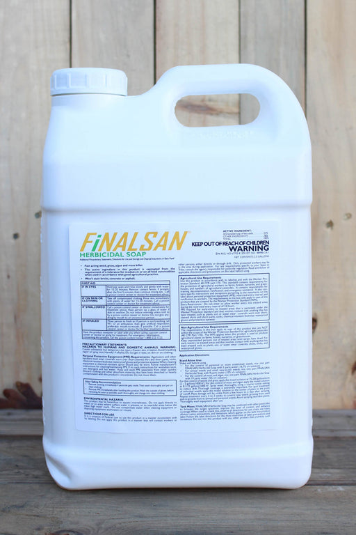 A large white plastic jug of Finalsan Herbicidal Soap standing on a wooden surface against a light wood plank background.