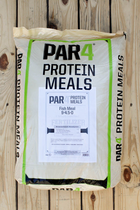 A large bag of PAR4 Protein Meals Fish Meal fertilizer placed on a light-colored wooden plank surface. The bag is off-white with green borders and black text, featuring a white label in the center.