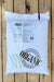 A large white bag of BioSystems Nitrogen 5-4-3 slow-release fertilizer with calcium, displayed on a light-colored wooden plank background.