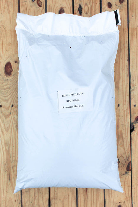 A large white plastic bag of coir with a printed label placed on a wooden plank surface.