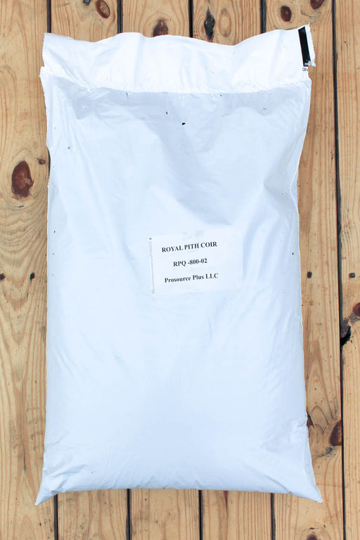 A large white plastic bag of coir with a printed label placed on a wooden plank surface.