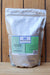 A 5 lb bag of Alpha Chemicals Ferrous Sulfate Heptahydrate, shown standing upright on a wooden surface against a wooden plank background.