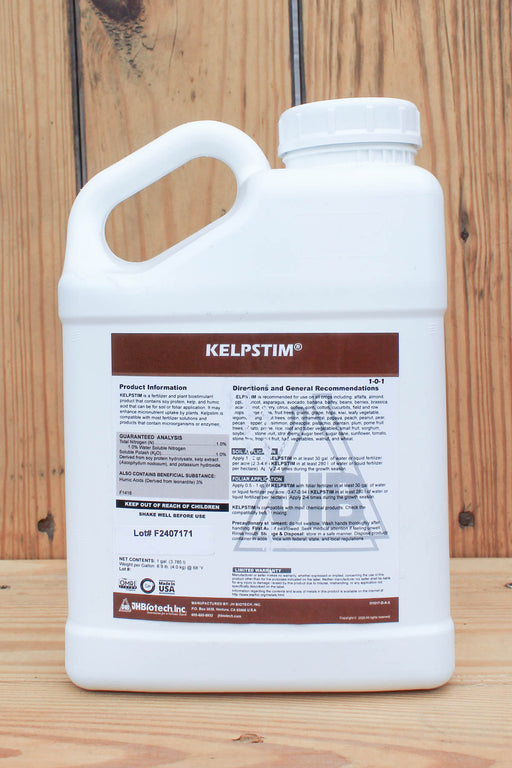 A white plastic jug of KelpStim liquid fertilizer with a brown and white label, set against a rustic wooden plank background.