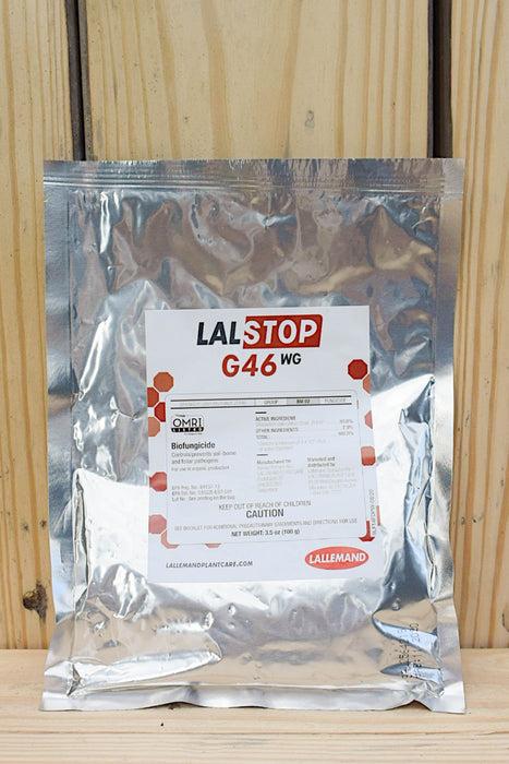 A silver pouch of LalStop G46 WG, featuring a white label with red and black text, set against a light wood plank background.