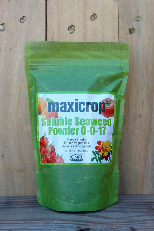 A green stand-up pouch of Maxicrop Soluble Seaweed Powder 0-0-17, displayed against a rustic wooden plank background.