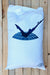 A large white sack with a dark blue graphic of a diving figure on a grid dome, placed on a light wood plank surface. A small circular logo is visible in the bottom right corner.