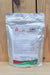 A silver stand-up pouch of MilAgro CalBor Organic 3-0-0 Soluble Powder Fertilizer standing on a light wood surface against a wooden plank background.