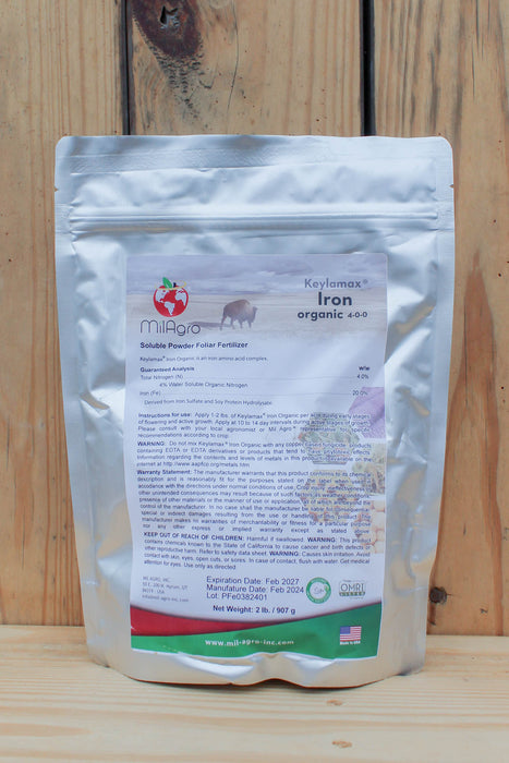 A stand-up pouch of MilAgro Keylamax Iron Organic 4-0-0 Soluble Powder Fertilizer, shown against a rustic wooden plank background.