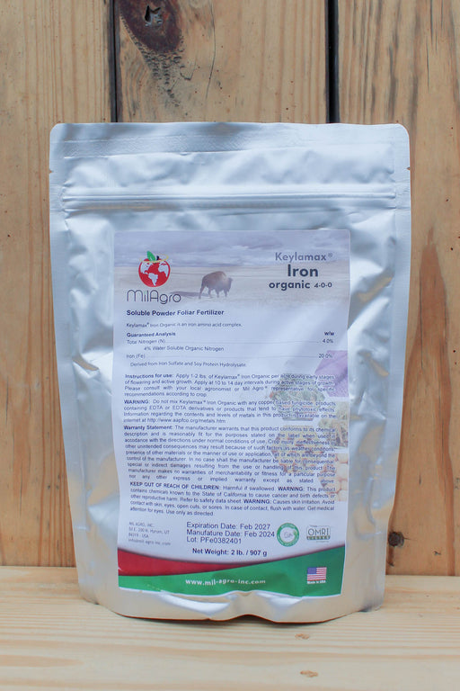 A stand-up pouch of MilAgro Keylamax Iron Organic 4-0-0 Soluble Powder Fertilizer, shown against a rustic wooden plank background.