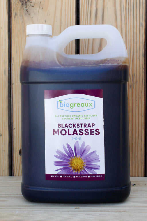 A large plastic jug of biogreaux Blackstrap Molasses fertilizer, filled with dark purple liquid, set against a rustic wooden plank background.
