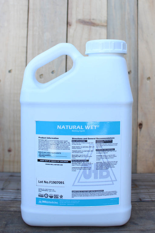 A large white plastic jug of Natural Wet , featuring a blue and white label, set against a rustic wooden plank background.