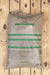 A large bag of Nature Safe fertilizer, 10-2-8 All-Season Formula, lying flat on a light-colored wooden plank surface.