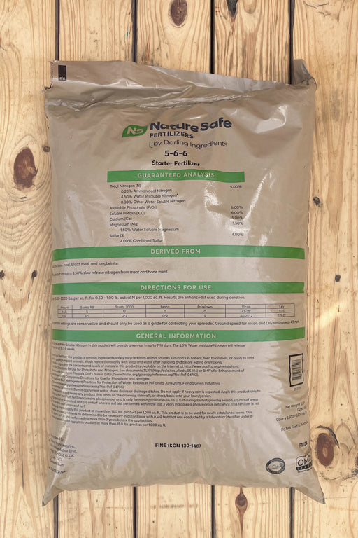 A large bag of Nourisafe Fertilizer 5-6-6 Starter Fertilizer, shown flat on a light-colored wooden plank background.