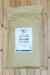 A large beige paper bag of Nature's Safe 7-7-7 fertilizer, displayed flat on a light-colored wooden plank surface.