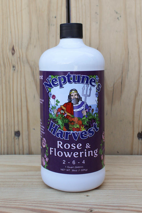 A white plastic bottle of Neptune's Harvest Rose & Flowering fertilizer with a black cap, set against a light wood plank background.