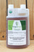 A 1-quart plastic jug of OrganiShield Biochemical Insecticide with a white cap and a white label featuring green leaf graphics, set against a rustic wooden plank background.