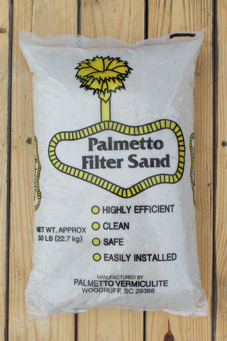 A 50 lb bag of Palmetto Filter Sand on a light wood plank background. The white bag features a yellow palm tree logo and a yellow outlined badge containing the text 'Palmetto Filter Sand'.