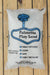 A 50 lb bag of Palmetto Play Sand, manufactured by Palmetto Vermiculite, displayed on a light-colored wooden plank background.