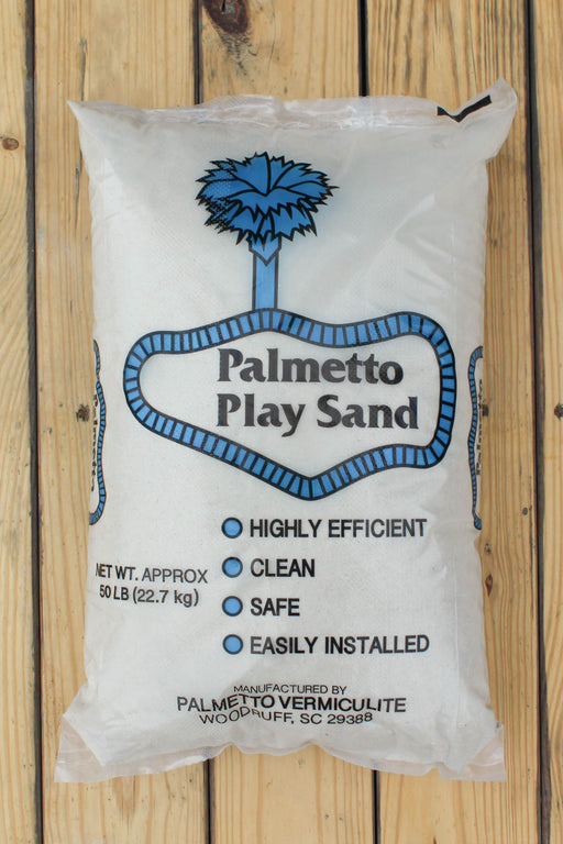 A 50 lb bag of Palmetto Play Sand, manufactured by Palmetto Vermiculite, displayed on a light-colored wooden plank background.
