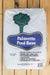 A 2 cu ft bag of Palmetto Pool Base pre-mixed pool filler for ground vinyl lined pools, displayed flat on a light wood plank surface. The white bag features a blue label with a green palm tree graphic.