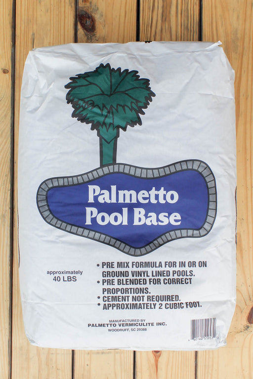 A 2 cu ft bag of Palmetto Pool Base pre-mixed pool filler for ground vinyl lined pools, displayed flat on a light wood plank surface. The white bag features a blue label with a green palm tree graphic.