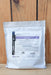 A white resealable stand-up pouch of BioWorks Principle WP standing upright against a light wood plank background.