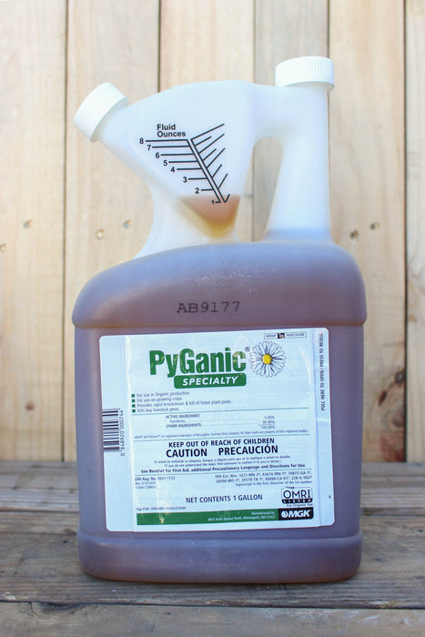 A gallon jug of PyGanic Specialty, featuring a white plastic spout and a translucent brown bottle, set against a rustic wooden plank background.