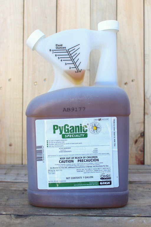 A gallon jug of PyGanic Specialty, featuring a white plastic spout and a translucent brown bottle, set against a rustic wooden plank background.