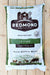 A large bag of Redmond Agriculture 10 Fine Premium Mineral Salt for livestock, displayed flat on a light-colored wooden plank surface.