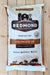 A large bag of Redmond Agriculture Selenium 90 Premium Mineral Salt for all classes of livestock, displayed flat on a light-colored wooden plank surface.