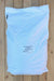 A large white plastic bag of Sulfate of Potash Organic fertilizer, labeled '00-00-50', laid flat on a light-colored wooden plank surface.