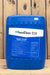 A large blue plastic jug of SaniDate 12.0 standing upright against a rustic wooden plank background.