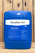 A large blue plastic jug of SaniDate 15.0, standing on a wooden surface against a vertical wood plank background.