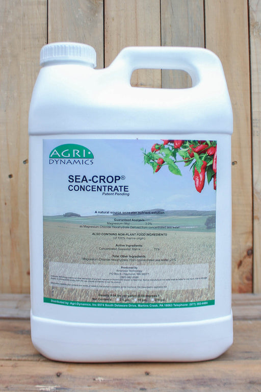 A white plastic jug of Sea-Crop Concentrate standing against a rustic wooden plank background.
