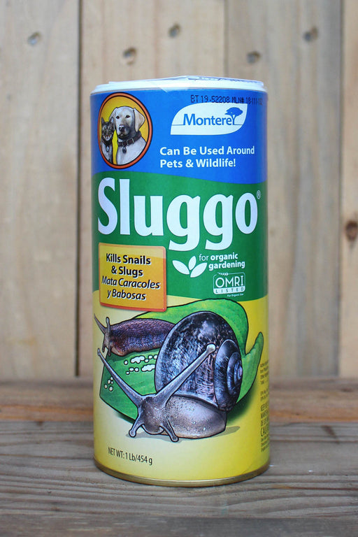 A canister of Sluggo slug and snail control product, featuring a blue, green, and yellow label with illustrations of snails, set against a rustic wooden background.