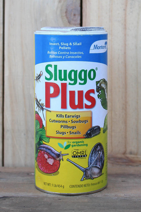 A canister of Sluggo Plus slug and snail pellets, featuring a blue, red, and yellow label, set against a rustic wooden background.
