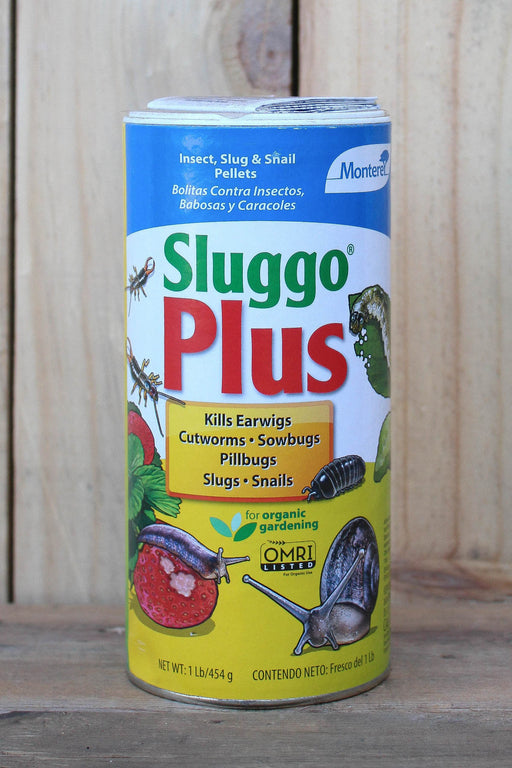 A canister of Sluggo Plus slug and snail pellets, featuring a blue, red, and yellow label, set against a rustic wooden background.