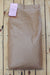 A large brown paper bag of Soybean Meal, with a pink paper label attached, laid flat on a light-colored wooden plank surface.
