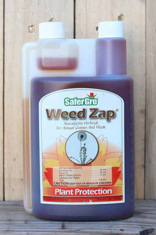 A bottle of SaferGro Weed Zap herbicide with a white cap and a clear side container, set against a rustic wooden plank background.