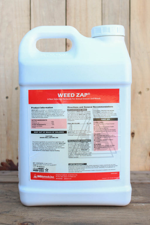 A white plastic jug of Weed Zap herbicide with a large red and black label, standing on a wooden surface against a wooden plank background.