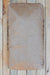 A brown paper bag of Vansil W-30 Wollastonite photographed from directly above on a light-colored wooden plank surface.