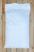 A large white woven sack of zeolite laid flat on a light natural wood plank surface.