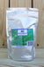 A silver stand-up pouch of Alpha Chemicals Zinc Sulfate Monohydrate, featuring a green and blue label, set against a light wood plank background.