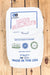 A white paper bag of Old Bridge Chemicals Zinc Sulfate, 25 kg, laid flat on a light-colored wooden plank surface. 
